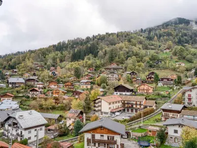 a table on a balcony with a view of the mountains at Triplex chaleureux avec wifi - 6 personnes - Proche centre - FR-1-663-6 in Saint-Gervais-les-Bains