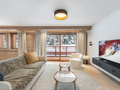 a living room with a couch and a tv at Appartement neuf avec terrasse, 2 chambres près des pistes, sauna, hammam, salle de sport, parking - FR-1-569-57 in Megève