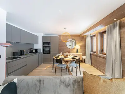 a kitchen and dining room with a table and chairs at Appartement neuf avec terrasse, 2 chambres près des pistes, sauna, hammam, salle de sport, parking - FR-1-569-57 in Megève
