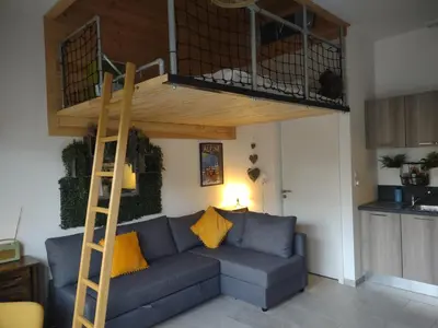 a living room with a couch and a loft bed at Roomy studio near town and ski lift, free WiFi and parking in Saint-Gervais-les-Bains