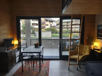 a living room with a table and a chair at Roomy studio near town and ski lift, free WiFi and parking in Saint-Gervais-les-Bains