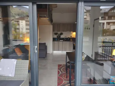 a view of a kitchen through a sliding glass door at Roomy studio near town and ski lift, free WiFi and parking in Saint-Gervais-les-Bains