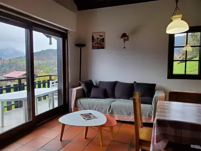 a living room with a couch and a table at Chalet à Cordon face à la chaîne du Mont Blanc in Cordon