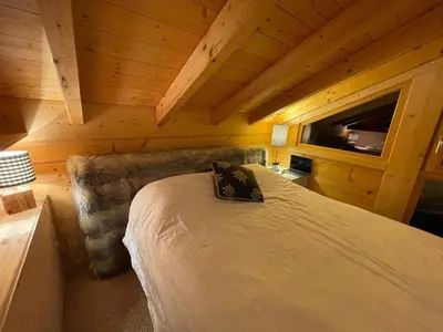 a bedroom with a bed in a wooden cabin at Chalet indépendant 8 pers, déco moderne, proche centre et remontées, terrasse sud-ouest - FR-1-572-32 in Arâches-la-Frasse