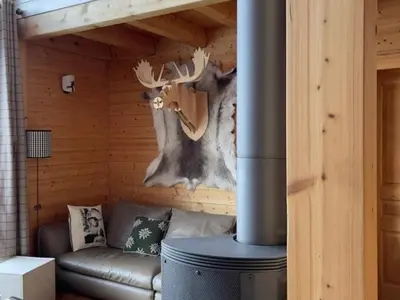 a living room with a fireplace with a moose mural at Chalet indépendant 8 pers, déco moderne, proche centre et remontées, terrasse sud-ouest - FR-1-572-32 in Arâches-la-Frasse