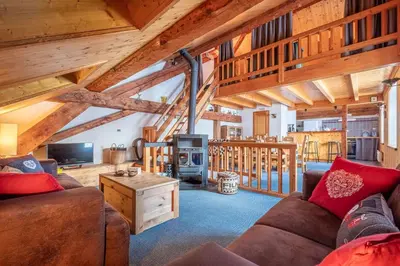 a living room with a couch and a stove at Chalet La Chapelle aux pieds des pistes in Chamonix-Mont-Blanc