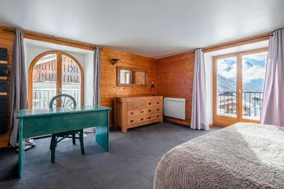 a bedroom with a white bed with a window at Chalet La Chapelle aux pieds des pistes in Chamonix-Mont-Blanc