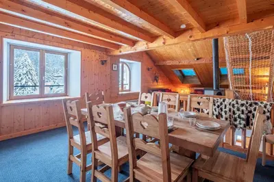 a dining room with a wooden table and chairs at Chalet La Chapelle aux pieds des pistes in Chamonix-Mont-Blanc