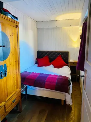 a bedroom with a bed with red pillows on it at Megève Rochebrune, 2 chambres cosy, terrasse, ski et centre à pied in Megève