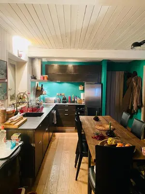 a kitchen with a wooden table and a kitchen with green walls at Megève Rochebrune, 2 chambres cosy, terrasse, ski et centre à pied in Megève