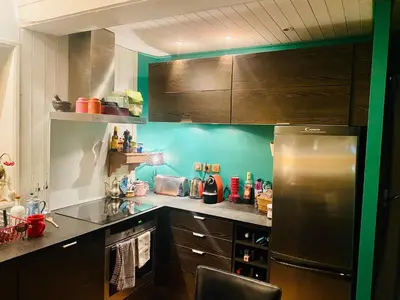 a kitchen with a stainless steel refrigerator and brown cabinets at Megève Rochebrune, 2 chambres cosy, terrasse, ski et centre à pied in Megève
