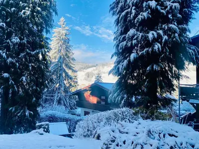 a house in the snow between two trees at Megève Rochebrune, 2 chambres cosy, terrasse, ski et centre à pied in Megève