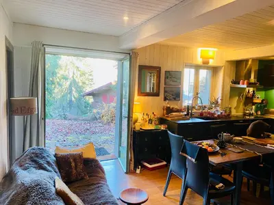a kitchen and living room with a couch and a table at Megève Rochebrune, 2 chambres cosy, terrasse, ski et centre à pied in Megève