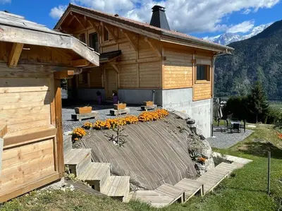 a house with a deck with flowers in front of it at Gîte Au Balcon de Passy/Plaine Joux, classé 2 ** in Passy
