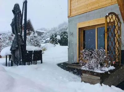 a house with snow on the ground next to a window at Gîte Au Balcon de Passy/Plaine Joux, classé 2 ** in Passy