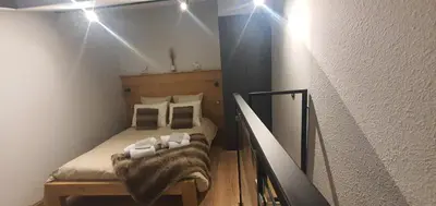 a small bedroom with a bed with white sheets and pillows at Duplex Aiguille du midi CHAMONIX in Chamonix-Mont-Blanc