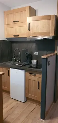 a kitchen with wooden cabinets and a white dishwasher at Duplex Aiguille du midi CHAMONIX in Chamonix-Mont-Blanc
