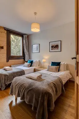 a bedroom with two beds and a couch at Apartment le Paradis 1 - Alpes Travel - Central Chamonix (sleeps 4) in Chamonix-Mont-Blanc