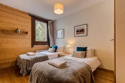 two beds in a room with wooden walls at Apartment le Paradis 1 - Alpes Travel - Central Chamonix (sleeps 4) in Chamonix-Mont-Blanc