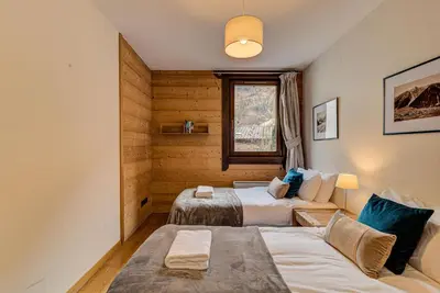a room with two beds and a couch at Apartment le Paradis 1 - Alpes Travel - Central Chamonix (sleeps 4) in Chamonix-Mont-Blanc
