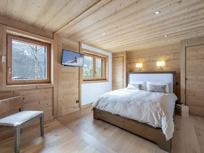 a bedroom with a bed and a window and a tv at Appartement neuf spacieux à Megève avec jardin privatif - FR-1-569-60 in Megève