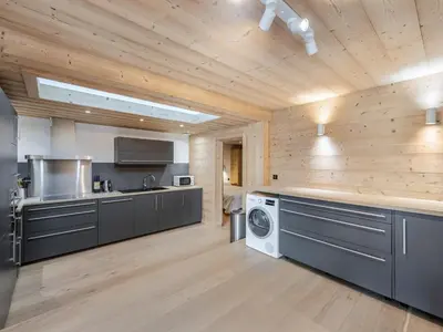a kitchen with a washer and dryer in a room at Appartement neuf spacieux à Megève avec jardin privatif - FR-1-569-60 in Megève