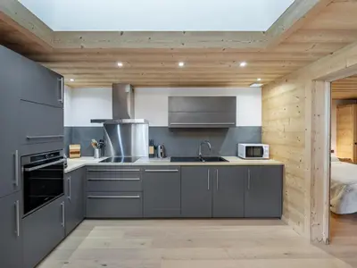 a kitchen with a sink and a stove top oven at Appartement neuf spacieux à Megève avec jardin privatif - FR-1-569-60 in Megève