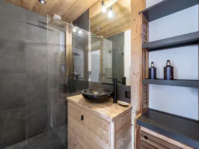 a bathroom with a sink and a glass shower at Appartement neuf spacieux à Megève avec jardin privatif - FR-1-569-60 in Megève