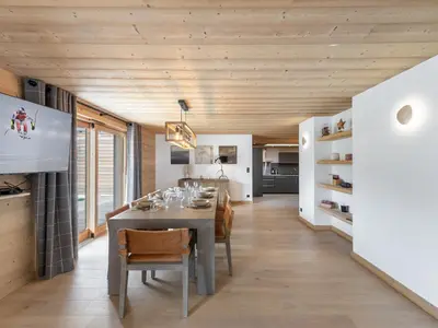 a kitchen and dining room with a table and chairs at Appartement neuf spacieux à Megève avec jardin privatif - FR-1-569-60 in Megève