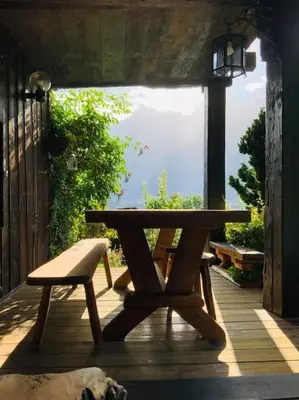 a wooden picnic table and a bench on a porch at Logement avec jardin et vue panoramique MontBlanc in Les Houches