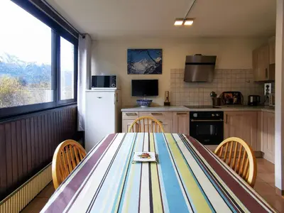 a kitchen with a table with chairs and a refrigerator at Sun Valley 3 - Vue Mont-Blanc in Chamonix-Mont-Blanc