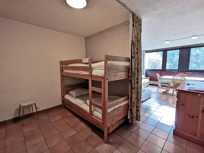 two bunk beds in a room with a kitchen at Sun Valley 3 - Vue Mont-Blanc in Chamonix-Mont-Blanc