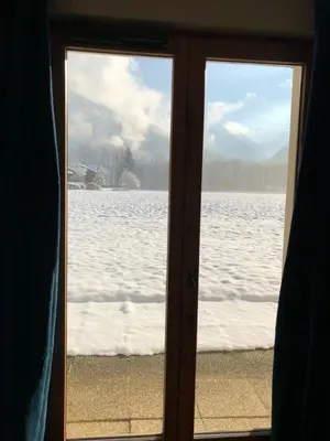 a sliding glass door with a view of a snow covered field at Studio - Le D2 du Grand Tetras in Samoëns