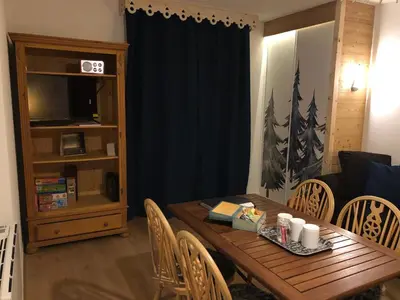a living room with a wooden table and chairs at Studio - Le D2 du Grand Tetras in Samoëns