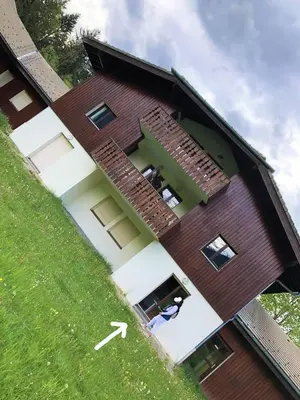 a building with a person looking out of a window at Studio - Le D2 du Grand Tetras in Samoëns