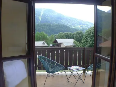 a room with a balcony with a bed and a chair at T2 avec mezzanine, balcon et parking à Samoëns - Pour télétravail - FR-1-629-115 in Samoëns