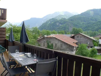 a table on a balcony with a view of mountains at T2 avec mezzanine, balcon et parking à Samoëns - Pour télétravail - FR-1-629-115 in Samoëns
