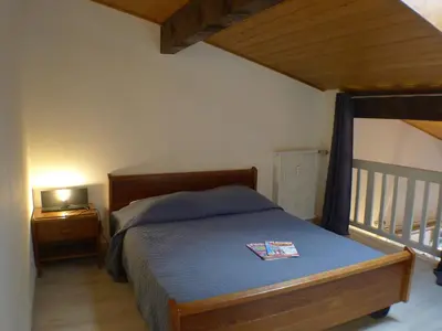 a bedroom with a bed with a wooden frame and a balcony at T2 avec mezzanine, balcon et parking à Samoëns - Pour télétravail - FR-1-629-115 in Samoëns