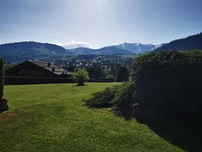 a field of grass with mountains in the background at MAGNIFIQUE Appart/ 8 pers / 4 ch / Jardin / Vue MB in Megève