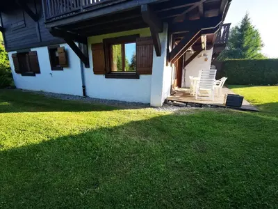 a house with two chairs on a porch at MAGNIFIQUE Appart/ 8 pers / 4 ch / Jardin / Vue MB in Megève