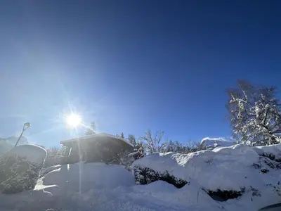 a snow covered car with the sun in the background at Chalet cosy 3 chambres pour 6 personnes à Arâches-la-Frasse, proche centre village et pistes. - FR-1-572-129 in Arâches-la-Frasse