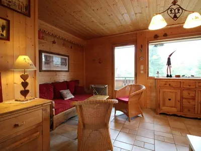 a living room with a red couch in a cabin at Chalet cosy 3 chambres pour 6 personnes à Arâches-la-Frasse, proche centre village et pistes. - FR-1-572-129 in Arâches-la-Frasse