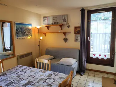 a room with a bed and a table and a window at Studio cosy 4 pers au cœur de la station, proche des pistes et commerces - FR-1-572-268 in Arâches-la-Frasse