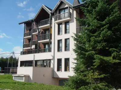 a tall white building with balconies and a tree at Studio cosy 4 pers au cœur de la station, proche des pistes et commerces - FR-1-572-268 in Arâches-la-Frasse