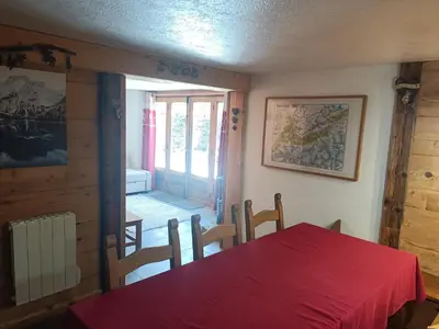 a dining room with a red table and a window at Three Bedroomed Chalet Apartment in Chamonix-Mont-Blanc