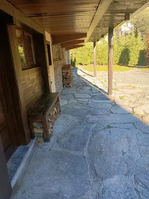 a wooden bench sitting under a porch of a building at Three Bedroomed Chalet Apartment in Chamonix-Mont-Blanc