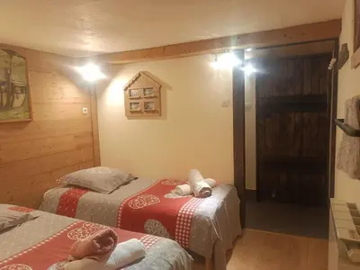 a bedroom with two beds and a window with a door at Three Bedroomed Chalet Apartment in Chamonix-Mont-Blanc