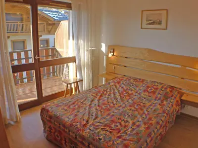 a bedroom with a bed and a balcony at T2 à Samoëns, animaux acceptés, parking - FR-1-629-67 in Samoëns
