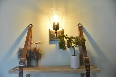 a lamp on a table with two chairs with a plant at Au Petit Bois in Chamonix-Mont-Blanc