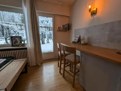 a kitchen with a counter and a table and a window at Au Petit Bois in Chamonix-Mont-Blanc
